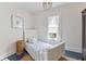 Bright bedroom featuring a white bed frame, blue striped bedding, and natural light from the window at 211 N County Line Rd, , IN 47272