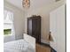 Charming bedroom with a large antique wardrobe, wood floors, and light from a window at 211 N County Line Rd, , IN 47272