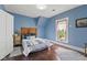 Bright blue bedroom showcasing hardwood floors, wood headboard and a view to the outside at 211 N County Line Rd, , IN 47272