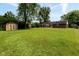 Sprawling, green backyard featuring a storage shed and mature trees for privacy at 220 E Tilden Dr, Brownsburg, IN 46112