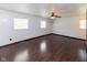 This spacious bedroom features stylish wood floors, a ceiling fan, and natural light from three windows at 220 E Tilden Dr, Brownsburg, IN 46112