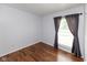 Neutral bedroom featuring hardwood floors, closet, and a large window with curtains at 220 E Tilden Dr, Brownsburg, IN 46112
