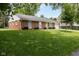 Well-maintained brick house with a green lawn and mature trees at 220 E Tilden Dr, Brownsburg, IN 46112