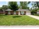 Charming brick home with attached garage, manicured lawn, and American flag at 220 E Tilden Dr, Brownsburg, IN 46112