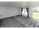 Spacious carpeted living room featuring a large window and sliding glass door at 220 E Tilden Dr, Brownsburg, IN 46112