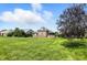 Well-maintained backyard with a brick house and lush green lawn under a blue sky with white clouds at 2251 Somerset Dr, Franklin, IN 46131