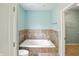 Well-lit bathroom boasts a soaking tub and tiled walls, offering a relaxing and luxurious experience at 2251 Somerset Dr, Franklin, IN 46131