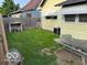 A view of the backyard featuring a grass lawn area, exterior table, and wooden fence at 2830 Guilford Ave, Indianapolis, IN 46205