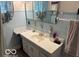 This bathroom features blue tiling, ample storage within the mirrored medicine cabinet and storage cabinet above the toilet at 2830 Guilford Ave, Indianapolis, IN 46205