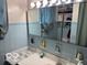 This bathroom features blue tiling, ample lighting above the sink and ample storage withing the mirrored medicine cabinet at 2830 Guilford Ave, Indianapolis, IN 46205