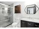 Modern bathroom with a glass-enclosed shower, stylish vanity with marble countertop, and eye-catching black and white flooring at 3210 Hovey St, Indianapolis, IN 46218