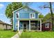 Charming two-story home with a welcoming front porch and a swing for relaxing, and manicured front lawn at 3210 Hovey St, Indianapolis, IN 46218