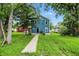 Charming two-story blue house with landscaped lawn, sidewalk, and mature trees at 3210 Hovey St, Indianapolis, IN 46218