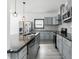 Modern kitchen with stainless steel appliances, sleek gray cabinets, a large island with a dark countertop at 3210 Hovey St, Indianapolis, IN 46218