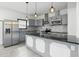 Modern kitchen with stainless steel appliances, gray cabinets, a large island, and pendant lighting, offering plenty of workspace at 3210 Hovey St, Indianapolis, IN 46218