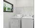 Bright laundry room featuring a washer, dryer, window and wire shelf at 3210 Hovey St, Indianapolis, IN 46218
