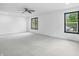 Spacious bedroom with a ceiling fan, multiple windows offering a view of the outdoors, and plush carpeting at 3210 Hovey St, Indianapolis, IN 46218