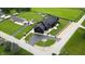 Stunning aerial view of a black luxury home, featuring a large yard, circular driveway, and beautiful landscaping at 3306 Mullinix Rd, Greenwood, IN 46143