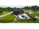 Stunning aerial view of a luxury home with a backyard pool, surrounded by lush greenery and manicured lawns at 3306 Mullinix Rd, Greenwood, IN 46143
