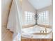 The bathroom features a tiled soaking tub, windows, and a decorative candle stand at 3306 Mullinix Rd, Greenwood, IN 46143