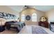 Spacious bedroom with unique wall art, high ceilings, arched windows, and a dark-colored bed at 3306 Mullinix Rd, Greenwood, IN 46143