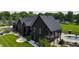 Striking black home featuring manicured lawn, a refreshing pool, and charming architectural details at 3306 Mullinix Rd, Greenwood, IN 46143