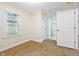 Bright bedroom with vinyl flooring, a window with blinds, and a door to the bathroom at 3562 E Morris St, Indianapolis, IN 46203