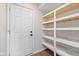 Pantry with multiple shelves on the right and a door on the left at 3931 Tekesbury Ct, Plainfield, IN 46168