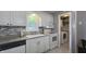 Cozy kitchen features white cabinets, stylish backsplash, stainless steel appliances and an adjacent laundry room at 408 Ottawa Dr, Indianapolis, IN 46217