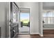 Open front door revealing a bright, inviting entryway with hardwood floors and a view of the neighborhood at 4281 Viewforth Ln, Bargersville, IN 46106