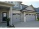 Close up of a two-car garage doors with white brick and stylish black front door at 4281 Viewforth Ln, Bargersville, IN 46106