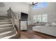Spacious living room boasts a high ceiling, plush sofa, and staircase with dark wood banister at 4281 Viewforth Ln, Bargersville, IN 46106