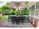 Outdoor dining set on a backyard deck with a large umbrella for shade on a sunny day at 4585 Abbey Dr, Carmel, IN 46033