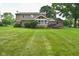 Well-maintained backyard with a charming sunroom extension, a spacious lawn, and mature trees providing ample shade at 4585 Abbey Dr, Carmel, IN 46033
