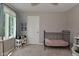 Calm bedroom featuring a dark metal crib, a window with curtains, and neutral colored walls at 4585 Abbey Dr, Carmel, IN 46033