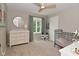 Serene bedroom with a changing table, round mirror, neutral walls, and natural light from a window at 4585 Abbey Dr, Carmel, IN 46033