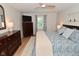This bedroom features a ceiling fan, a patterned comforter, and hardwood floors at 4585 Abbey Dr, Carmel, IN 46033