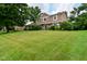 Traditional two-story house with a well-maintained green lawn, mature trees, and manicured landscaping at 4585 Abbey Dr, Carmel, IN 46033