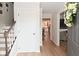 Inviting foyer featuring hardwood floors, a staircase, and views into the kitchen and living areas at 4585 Abbey Dr, Carmel, IN 46033