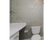 Elegant bathroom features white vanity, modern toilet, and designer wallpaper at 49 Druid Hill Ct # 0, Carmel, IN 46032