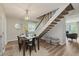 Dining room features modern lighting, dining table, and access to the staircase at 49 Druid Hill Ct # 0, Carmel, IN 46032
