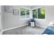 Bright bedroom boasts chair near sunny windows with white trim, light gray walls, gray carpet, and fresh decor at 5170 Mt Pleasant N St, Greenwood, IN 46142