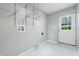 Bright laundry room with a white door, tiled floors, and metal shelving for storage at 5170 Mt Pleasant N St, Greenwood, IN 46142
