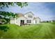 Large backyard features a well-manicured lawn, patio seating, and a white two-story house at 5294 Lndg Pl Ln, Noblesville, IN 46062