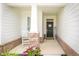Inviting front porch featuring brick columns, a cozy chair, and a welcoming entrance at 5294 Lndg Pl Ln, Noblesville, IN 46062
