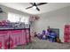 This bedroom is bright and spacious, featuring carpet flooring, ceiling fan and a large window at 5386 W 1100, Fountaintown, IN 46130