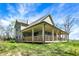 Beautiful home with a wrap-around porch, complemented by lush landscaping, offering a serene outdoor living space at 5386 W 1100, Fountaintown, IN 46130