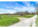 Scenic view of a lush, expansive yard with a charming home in the distance with a red barn at 5386 W 1100, Fountaintown, IN 46130
