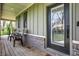 Cozy front porch with two chairs, dark trim windows, and a stylish front door at 5386 W 1100, Fountaintown, IN 46130