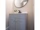 Modern bathroom featuring a gray vanity, sleek black faucet, and stylish round mirror at 5511 E University Ave, Indianapolis, IN 46219